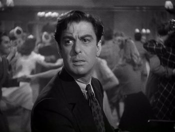 Movie still from “Blues in the Night” (1941), directed by Anatole Litvak – A black and white photo of a man in a suit and tie; Close Up shot, Low angle