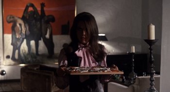 Movie still from “Bob & Carol & Ted & Alice” (1969), directed by Paul Mazursky – A woman holding a tray of pizza in a kitchen; Medium shot, Low angle