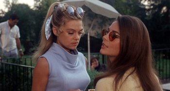 Two women are talking outside in the sun