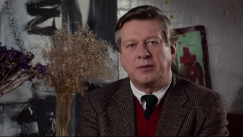 Movie still from “Bob Roberts” (1992), directed by Tim Robbins – A person wearing a suit and tie; Close Up shot, Low angle