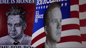 Movie still from “Bob Roberts” (1992), directed by Tim Robbins – A political poster of a man with a bald head; Close Up shot, Overhead angle