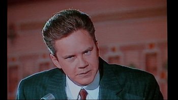Movie still from “Bob Roberts” (1992), directed by Tim Robbins – A person wearing a suit and tie; Close Up shot, Low angle