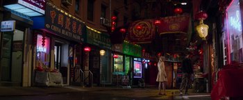 Movie still from “The Amazing Spider-Man 2” (2014), directed by Marc Webb – A woman standing on the sidewalk in front of an asian restaurant; Extreme Wide shot, High angle