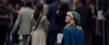 Movie still from “The Amazing Spider-Man 2” (2014), directed by Marc Webb – A woman in a green hat looking up at a crowd; Medium shot, Over the shoulder angle