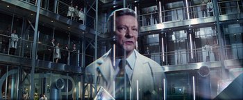 Movie still from “The Amazing Spider-Man 2” (2014), directed by Marc Webb – A man wearing a white lab coat standing in front of a building; Medium shot, Low angle
