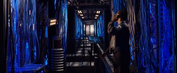 Movie still from “The Amazing Spider-Man 2” (2014), directed by Marc Webb – A man standing in a room with blue lights; Wide shot, Over the shoulder angle