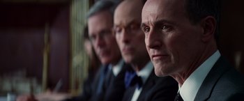 Movie still from “The Amazing Spider-Man 2” (2014), directed by Marc Webb – A group of men in suits sitting in a row; Close Up shot, Low angle