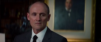 Movie still from “The Amazing Spider-Man 2” (2014), directed by Marc Webb – A man wearing a suit and tie in front of a painting; Close Up shot, Low angle