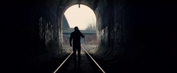 Movie still from “The Amazing Spider-Man 2” (2014), directed by Marc Webb – A man standing in a tunnel with a cell phone to his ear; Wide shot, High angle