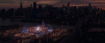 Movie still from “The Amazing Spider-Man 2” (2014), directed by Marc Webb – A city lit up at night with lights and a large body of water in front of it; Extreme Wide shot, High angle