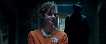 Movie still from “The Amazing Spider-Man 2” (2014), directed by Marc Webb – A man in an orange t - shirt is smiling; Close Up shot, Over the shoulder angle