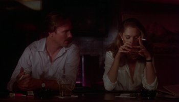 Movie still from “Body Heat” (1981), directed by Lawrence Kasdan – A man and a woman sitting at a bar; Medium shot, Over the shoulder angle