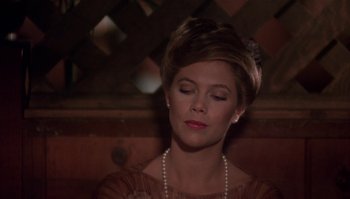 Movie still from “Body Heat” (1981), directed by Lawrence Kasdan – A beautiful woman with short brown hair wearing pearls; Close Up shot, Over the shoulder angle