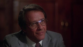 Movie still from “Body Heat” (1981), directed by Lawrence Kasdan – An older man wearing glasses and a suit and tie; Close Up shot, Over the shoulder angle