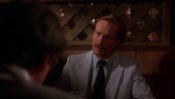 Movie still from “Body Heat” (1981), directed by Lawrence Kasdan – A man sitting at a table in front of another man in a suit; Close Up shot, Over the shoulder angle