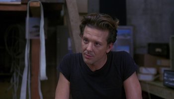 Movie still from “Body Heat” (1981), directed by Lawrence Kasdan – A person wearing a black t - shirt; Close Up shot, Over the shoulder angle