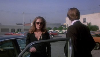 Movie still from “Body Heat” (1981), directed by Lawrence Kasdan – A woman standing next to a man in front of a car; Medium shot, Over the shoulder angle