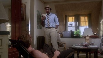 Movie still from “Body Heat” (1981), directed by Lawrence Kasdan – A man standing in a living room holding a phone; Medium shot, Low angle
