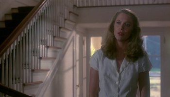 Movie still from “Body Heat” (1981), directed by Lawrence Kasdan – A woman standing in front of a staircase in a house; Medium shot, Low angle