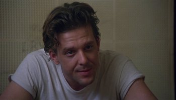 Movie still from “Body Heat” (1981), directed by Lawrence Kasdan – A person wearing a white t - shirt; Close Up shot, Over the shoulder angle