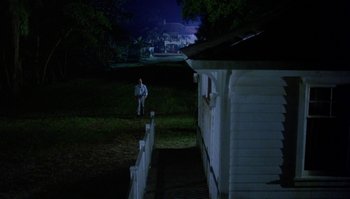 Movie still from “Body Heat” (1981), directed by Lawrence Kasdan – A man standing in a yard at night; Extreme Wide shot, Low angle