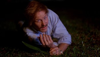 Movie still from “Body Heat” (1981), directed by Lawrence Kasdan – A man laying in the grass at night; Close Up shot, High angle