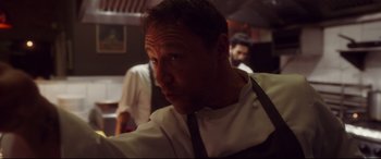 A man in a chef's outfit looking into the camera