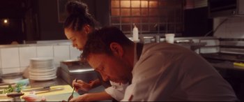 A man and a woman working in a restaurant kitchen