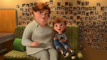 Movie still from “Bolt” (2008), directed by Chris Williams – An animated woman sitting next to a boy on a couch; Wide shot, High angle