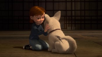 Movie still from “Bolt” (2008), directed by Chris Williams – A girl sitting on the ground petting a white dog; Medium shot, High angle