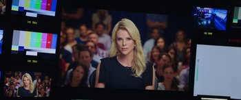 Movie still from “Bombshell” (2019), directed by Jay Roach – A woman in a black dress in front of an audience; Close Up shot, Over the shoulder angle