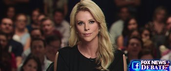Movie still from “Bombshell” (2019), directed by Jay Roach – A woman with long blonde hair wearing a black top; Close Up shot, Over the shoulder angle