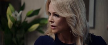 Movie still from “Bombshell” (2019), directed by Jay Roach – A woman with blonde hair looking to her left; Close Up shot, Over the shoulder angle