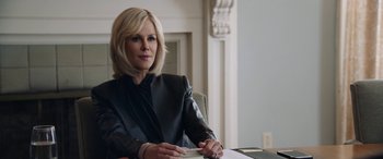 Movie still from “Bombshell” (2019), directed by Jay Roach – A woman sitting at a table in front of papers; Close Up shot, Over the shoulder angle