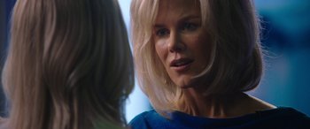 Movie still from “Bombshell” (2019), directed by Jay Roach – A woman with blonde hair is looking at the camera; Close Up shot, Over the shoulder angle