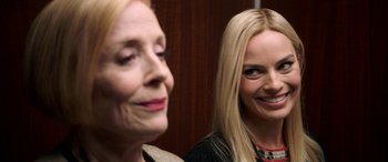 Movie still from “Bombshell” (2019), directed by Jay Roach – Two women smiling for the camera in front of each other; Close Up shot, Over the shoulder angle