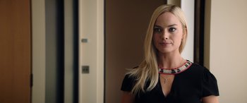 Movie still from “Bombshell” (2019), directed by Jay Roach – A beautiful blonde woman with long hair wearing a black shirt; Close Up shot, Over the shoulder angle