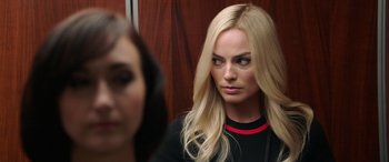 Movie still from “Bombshell” (2019), directed by Jay Roach – A woman with long blonde hair looking at the camera; Close Up shot, Over the shoulder angle