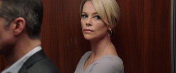 Movie still from “Bombshell” (2019), directed by Jay Roach – A woman with blonde hair wearing a gray shirt; Close Up shot, Over the shoulder angle