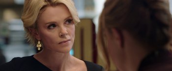 Movie still from “Bombshell” (2019), directed by Jay Roach – A woman looking into a mirror while wearing a black dress; Close Up shot, Over the shoulder angle