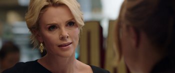 Movie still from “Bombshell” (2019), directed by Jay Roach – A person wearing a black shirt; Close Up shot, Over the shoulder angle