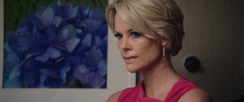 Movie still from “Bombshell” (2019), directed by Jay Roach – A person with blonde hair wearing a pink dress; Close Up shot, Over the shoulder angle