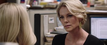 Movie still from “Bombshell” (2019), directed by Jay Roach – A woman with blonde hair is looking at the camera; Close Up shot, Over the shoulder angle