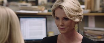 Movie still from “Bombshell” (2019), directed by Jay Roach – A person wearing a black shirt; Close Up shot, Over the shoulder angle