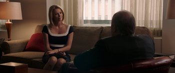 Movie still from “Bombshell” (2019), directed by Jay Roach – A woman sitting on a couch talking to a man; Medium shot, Over the shoulder angle