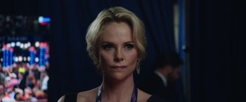 Movie still from “Bombshell” (2019), directed by Jay Roach – A person with short blonde hair; Close Up shot, Over the shoulder angle