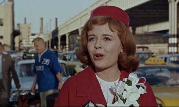 Movie still from “Bon Voyage!” (1962), directed by James Neilson – A woman in a red jacket and a red hat; Close Up shot, Over the shoulder angle