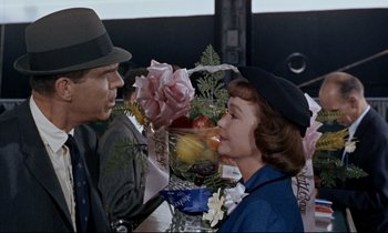 Movie still from “Bon Voyage!” (1962), directed by James Neilson – A man and a woman are eating fruit together; Medium shot, Over the shoulder angle