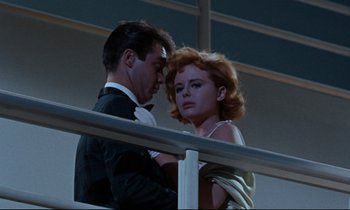 Movie still from “Bon Voyage!” (1962), directed by James Neilson – A man and a woman standing next to a railing; Medium shot, Low angle