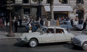 Movie still from “Bon Voyage!” (1962), directed by James Neilson – A car driving down a street past a crowd of onlookers; Extreme Wide shot, High angle